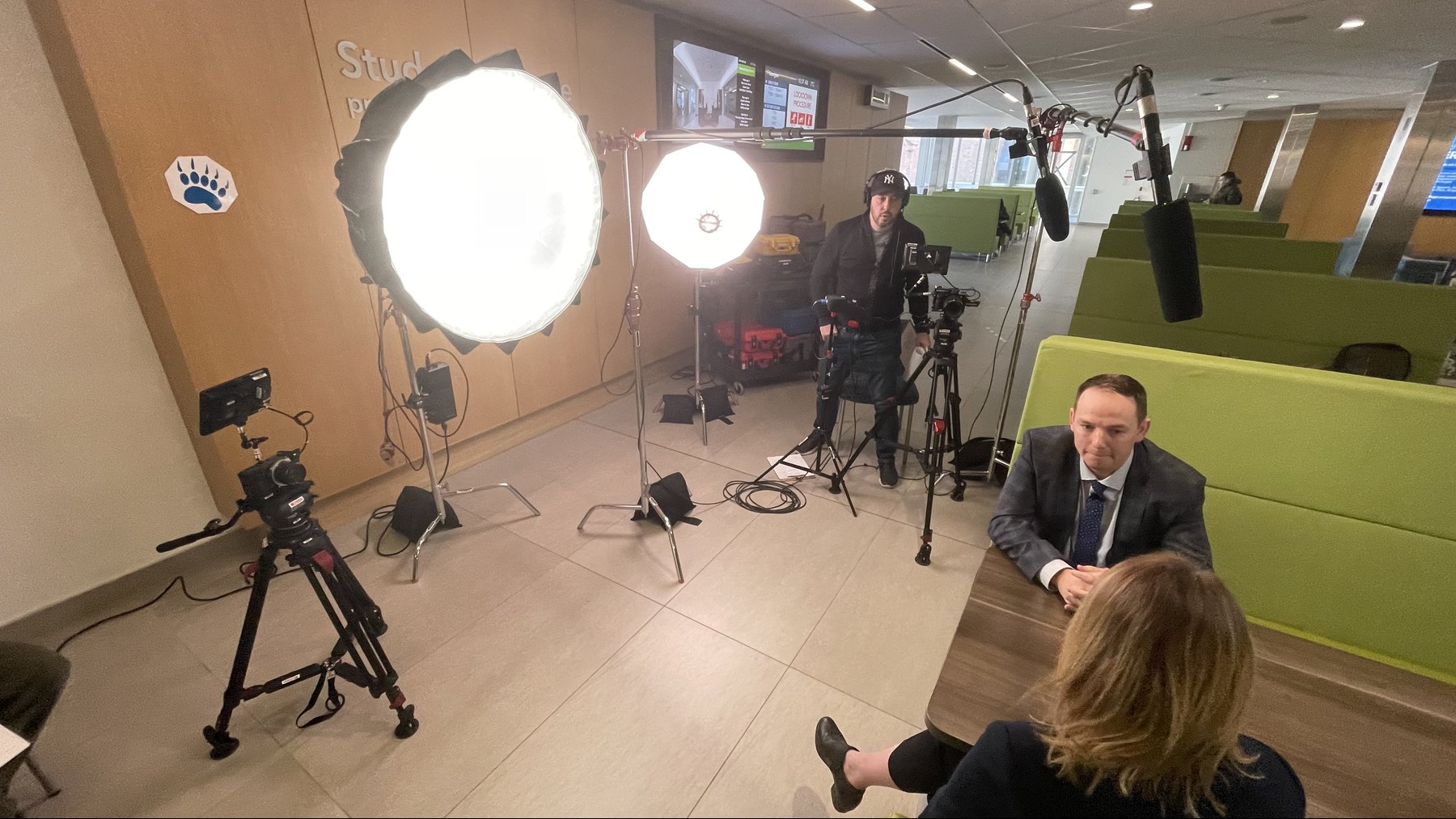 Interview participants and crew within a lighting, sound and two-camera setup on location